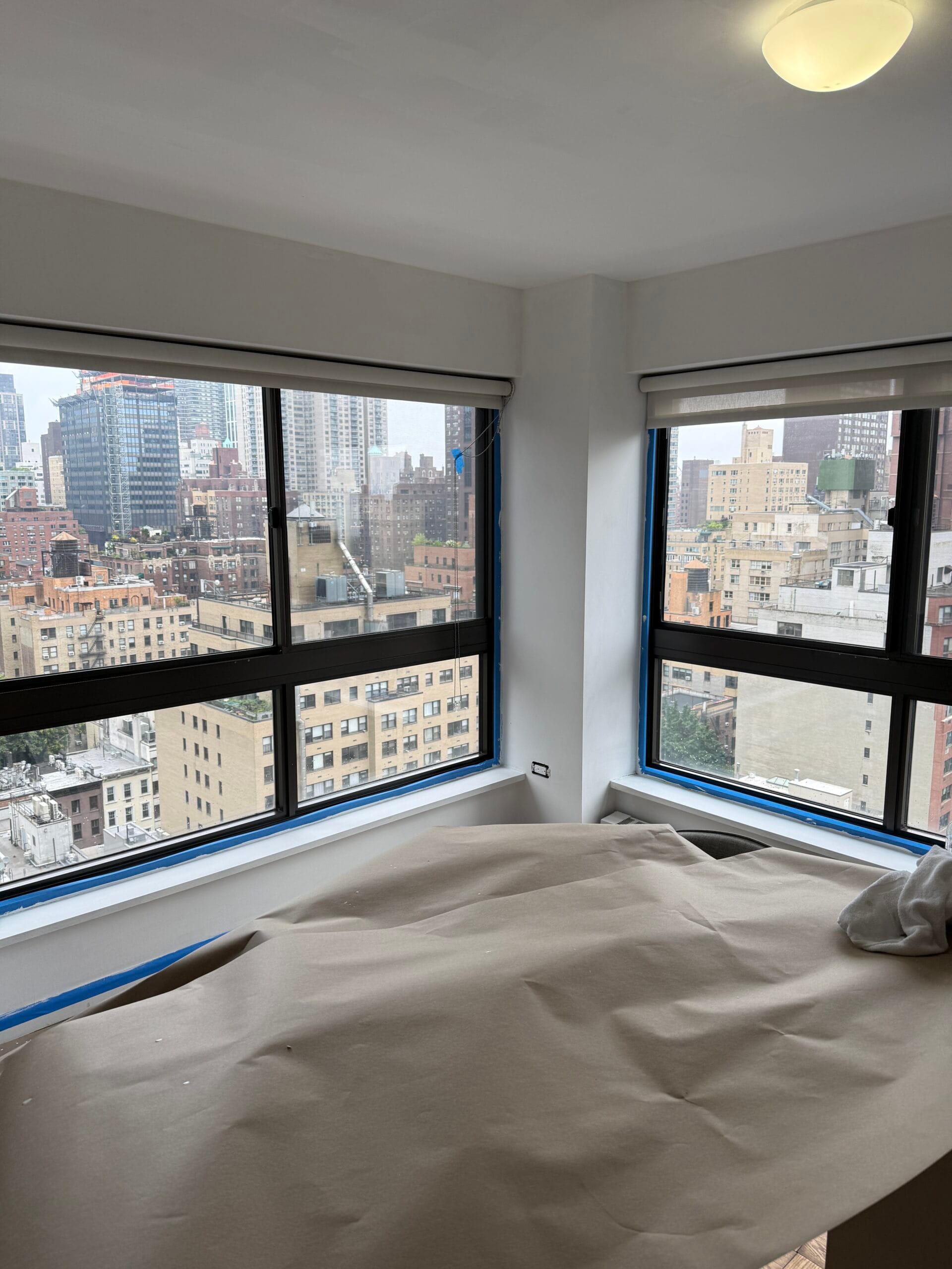Interior painting in progress - accent wall with blue tape protection in Midtown East apartment turnover